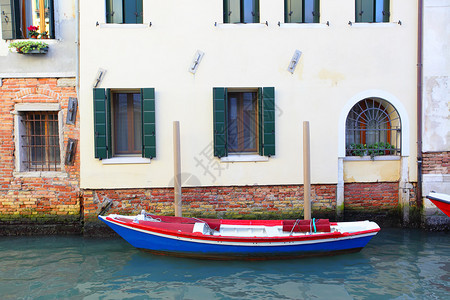 在威尼斯意大利狭小运河附近房屋的船只图片