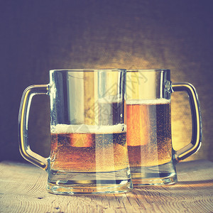 木制桌上的啤酒杯图片
