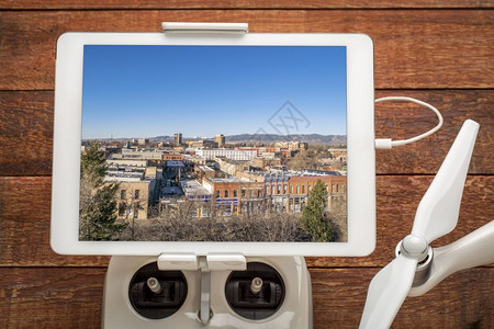 柯林斯堡市中心审查无人机线电控制器上安装的数字平板上空中图像图片