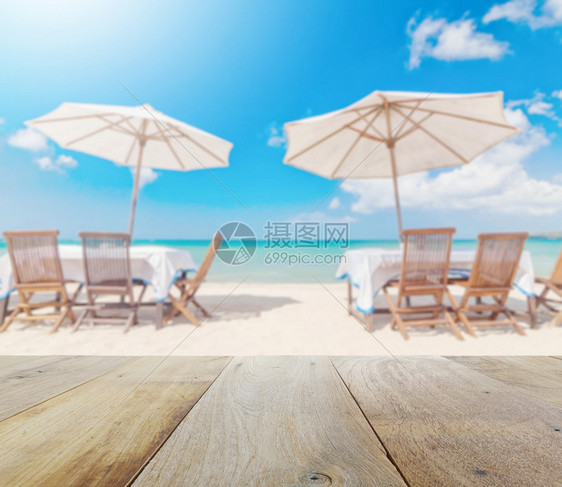 海滩上布满桌和雨伞模糊的木板桌顶图片