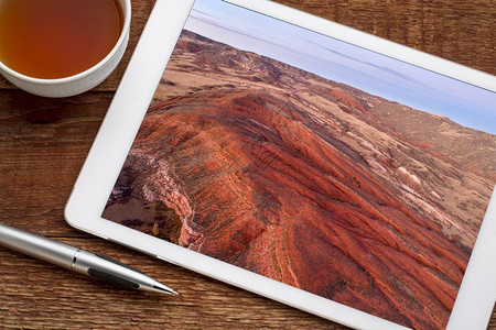 在科罗拉多北部洛基山丘陵的上空用红色沙石和峡谷在数字平板上审查空中图像图片