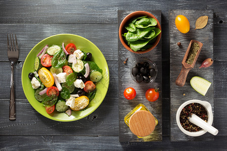 盘中的新鲜希腊沙拉和木制桌上的成分图片