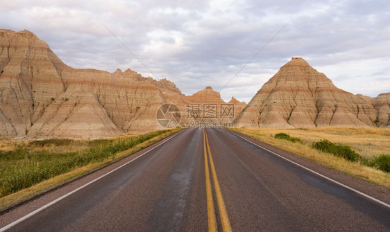 这条道路穿过南达科他州巴德兰的岩层图片