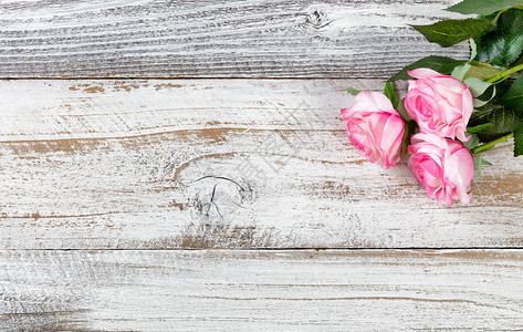 母亲节以红玫瑰在生锈的白木上庆祝图片