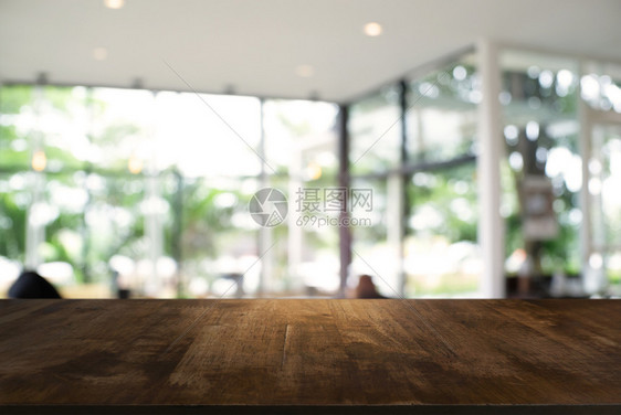在餐厅的抽象模糊布基背景面前的空黑木桌可以用于显示或调制您的产品图片