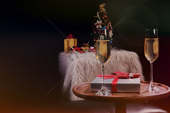 庆祝圣诞节或新年庆祝人们的手与水晶杯满香槟的子在圣诞树附近图片