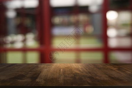 在咖啡馆和店内部的抽象模糊背景面前的空黑木桌可用于显示或调制产品图片