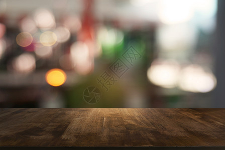 在咖啡馆和店内部的抽象模糊背景面前的空黑木桌可用于显示或调制产品背景图片