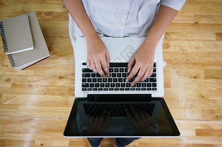 临时商业女在网上用笔记本电脑工作笔记本电脑在她家里的键盘上手动用笔记本电脑隔离屏幕图片