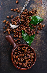 桌上的咖啡豆和绿叶图片