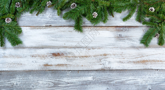 圣诞树的顶端边框枝和松锥以平整的固定形式在生锈的木头上图片