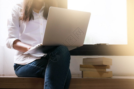 妇女自由职业者正在致力于一个新的项目即膝上型计算机时髦女孩键盘在网上同时在家里放松图片
