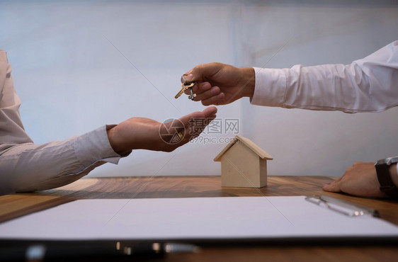 签署合同后向客户提供钥匙的房地产经纪人图片