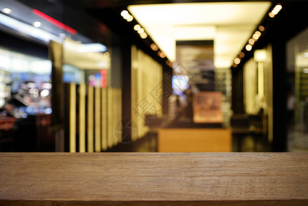 咖啡馆和厅内部的抽象模糊背景面前的空暗黑木桌可用于展示或装配产品图片