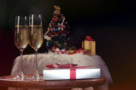 庆祝圣诞节或新年庆祝人们的手与水晶杯满香槟的子在圣诞树附近图片
