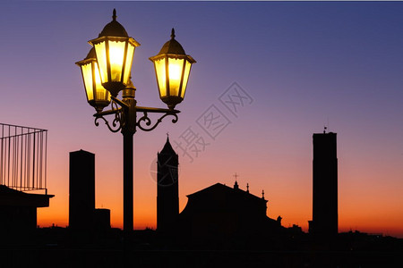 意大利波洛尼亚博塔楼和屋顶的空中观察意大利艾米亚罗马尼波洛大教堂的夜间空中观察和世纪城市博洛尼亚的老城塔楼日落时用古老的美丽灯笼图片