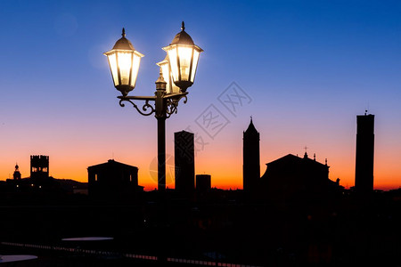 博洛尼亚波德斯意大利波洛尼亚博塔楼和屋顶的空中观察意大利艾米亚罗马尼波洛大教堂的夜间空中观察和世纪城市博洛尼亚的老城塔楼日落时用古老的美丽灯笼背景