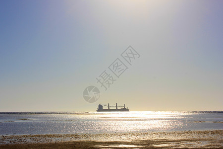 海上船帆在阳光照耀时沿海岸航行图片