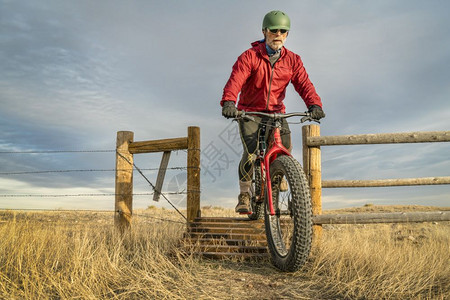 一名老年男子骑着一辆山地肥自行车骑着一辆山地肥自行车骑着在科罗拉多州北部Prairie自然区后秋天的SoapstonePrair图片