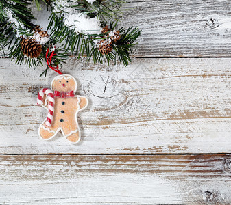 圣诞饼干装饰品挂在粗的fir树枝上挂在生锈的白色木背景上图片