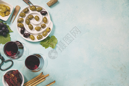 奶酪甲基橄榄黑和绿葡萄以及深底顶视复制空间的红葡萄酒杯图片