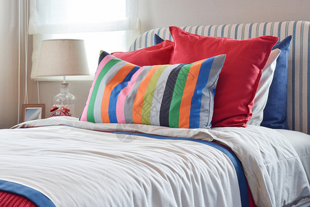 在白床单上挂有彩色枕头和条纹的板上挂有彩色枕头和白床单上挂有条纹枕头图片