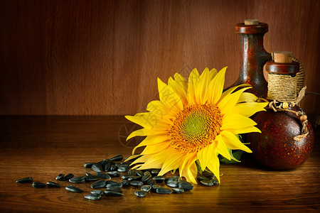 陶瓷瓶中的植物油和木本底的向日葵籽中植物油健康食品免费文本空间图片