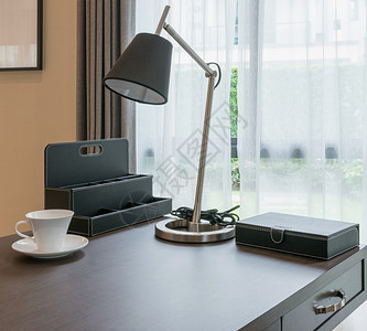 室内现代工作配有白色咖啡杯和阅读灯的木制桌图片