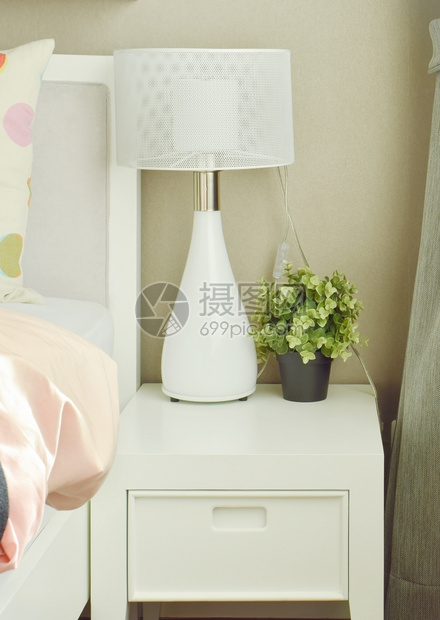 床边桌旁的白灯和花盆图片