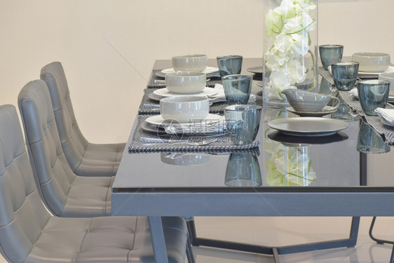 餐厅内装有现代风格餐具的玻璃顶端桌图片