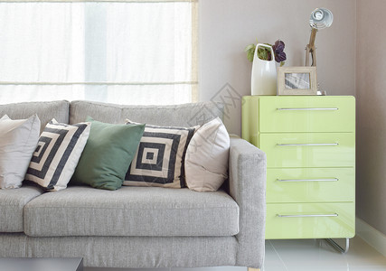 舒适的沙发带有几何式枕头和生活角的绿边板背景图片
