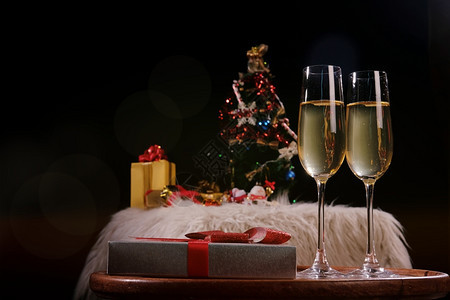 庆祝圣诞节或新年庆祝人们的手与水晶杯满香槟的子在圣诞树附近背景图片