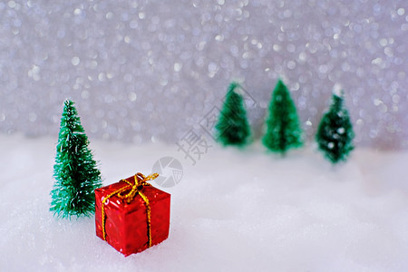 在雪中装上小手工礼品盒的圣诞家居装饰覆盖迷你长青森林和用于复制空间的bokeh光图片