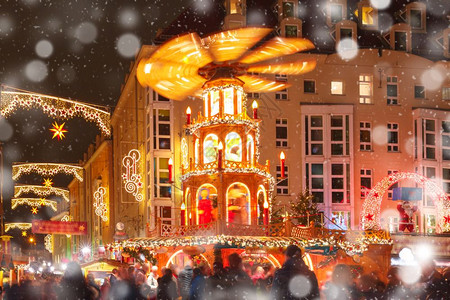 在德国累斯顿市的圣诞夜街上装饰和照亮圣诞街在德国萨克森州累斯顿市的雪上圣诞节晚宴配有旋转木马和背景图片