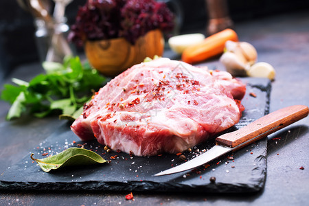 餐桌上加盐和香料的生肉图片