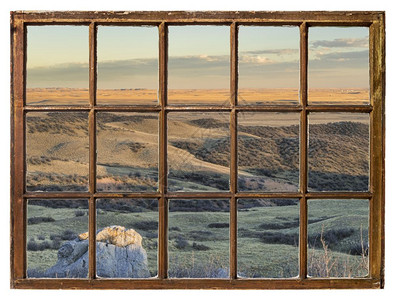 在科罗拉多山丘的日落时草原上从古老的被冷漠用脏玻璃砸碎的窗户中可以看到图片