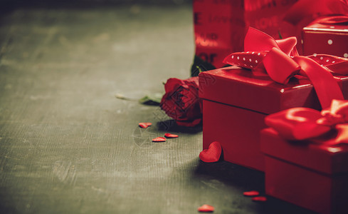 情人节日概念在木制背景上的红弓礼物情人节盒和在锈制背景上的红丝带弓捆绑在一起图片