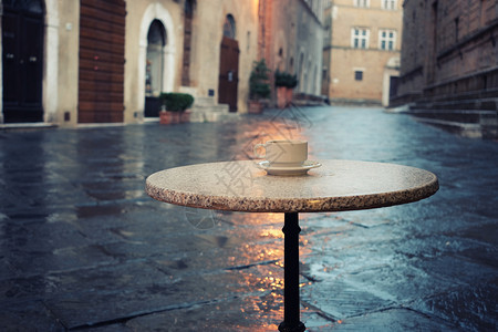 在旧的欧洲城市街头咖啡桌上喝着一杯咖啡图片