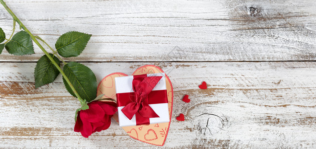挂在卡片上方的情人节礼物盒上面有玫瑰和心形在高空视图布局中图片