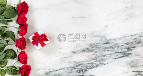 红玫瑰和礼品盒在大理石背景上形成左边图片