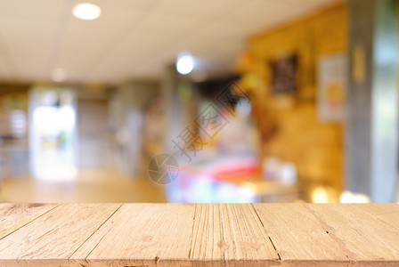 咖啡店的抽象模糊背景面前的空木制桌可用于显示或装配产品图片