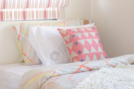 粉红三角型枕头放在甜色风格卧室角的床上图片
