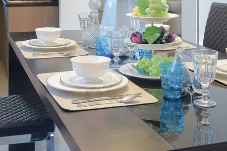餐桌上的具装配淡蓝色晶玻璃和水果图片