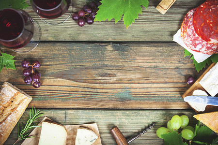 食物框酒和零配有红酒的杯子肉类品种面包奶酪和葡萄以生木背景顶视图中间空复制图片
