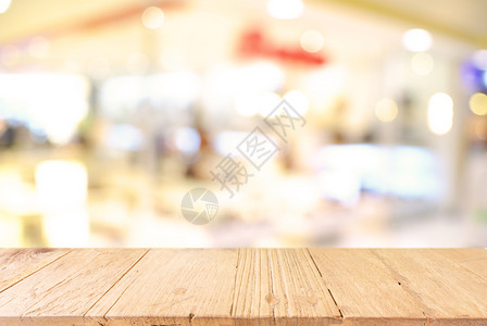 咖啡店的抽象模糊背景面前的空木制桌可用于显示或装配产品背景图片