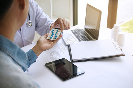 医生手持不同的药片水泡供病人使用开药疾病治疗概念图片