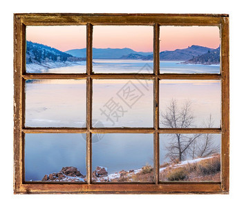 冬天在山湖的黄昏过冬从古老的冷用脏玻璃砸碎的窗户中看到图片