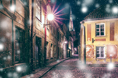 爱沙尼亚塔林市中世纪老城和圣奥拉夫浸信会冬季寒夜的圣奥拉夫浸信教堂的狭窄街道照亮爱沙尼亚塔林旧城夜街图片