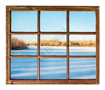 长树影的冰冻湖从古老的冷藏用脏玻璃砸碎的窗户中可以看到图片