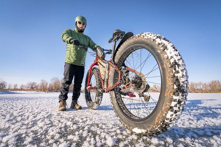 一名男骑自行车的手在冬季着肥山车在科罗拉多州北部寒冷的日图片